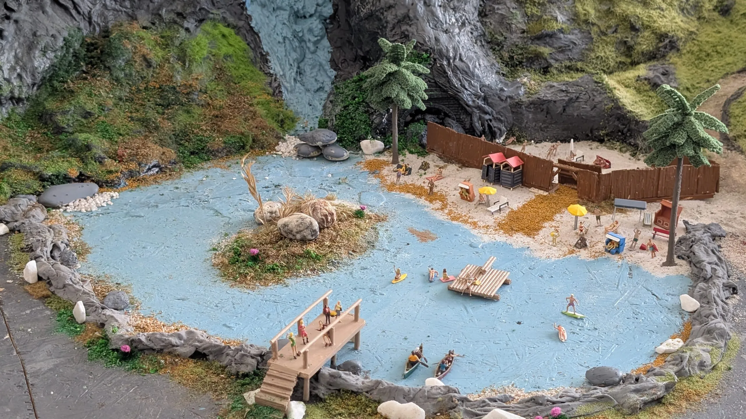 Hier entsteht der Badesee, auf dem Boote und Surfer unterwegs sind, während Badegäste das kühle Wasser genießen
