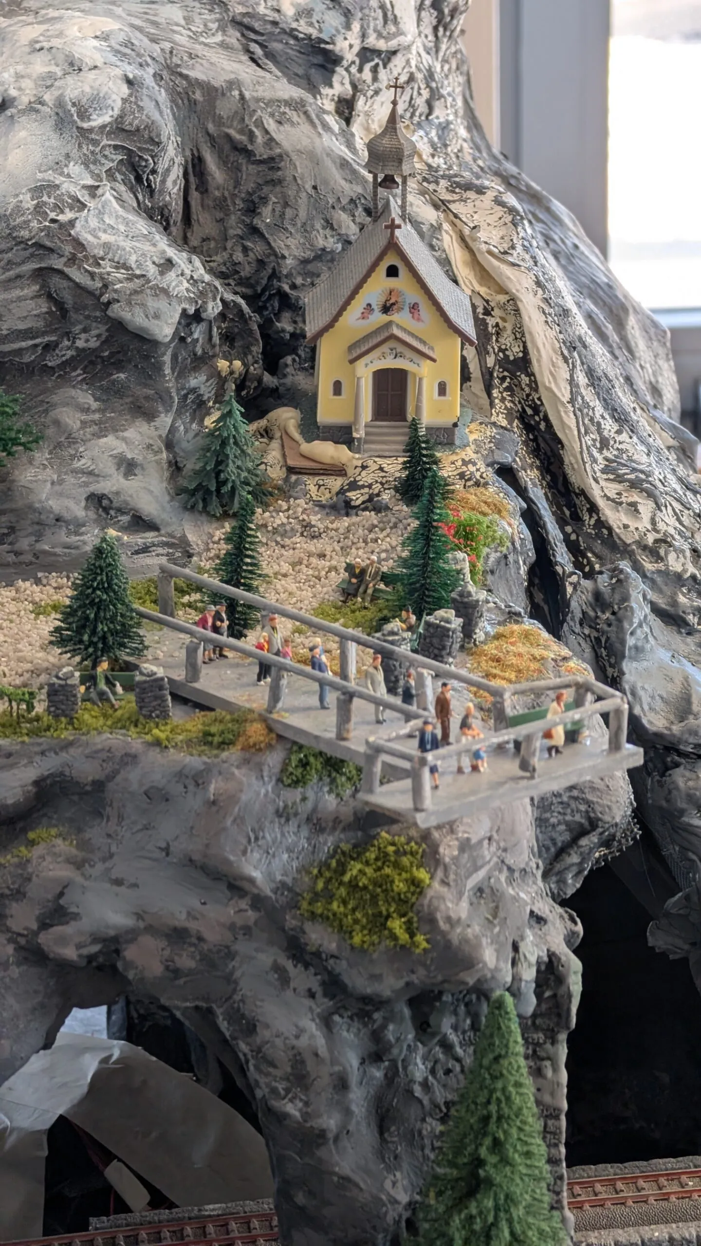 Nach dem langen Aufstieg erreichen die Wanderer die kleine Kapelle. Vom Aussichtssteg blicken sie hinunter auf die Stadt, die noch entsteht